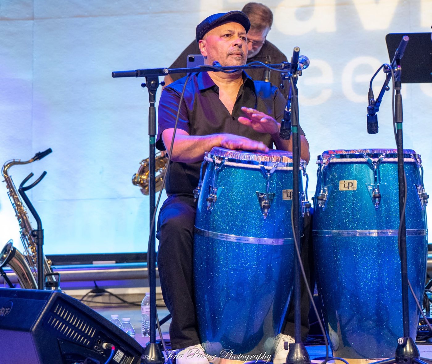 Hector Rosado playing congas on stage with his Orquesta HACHE